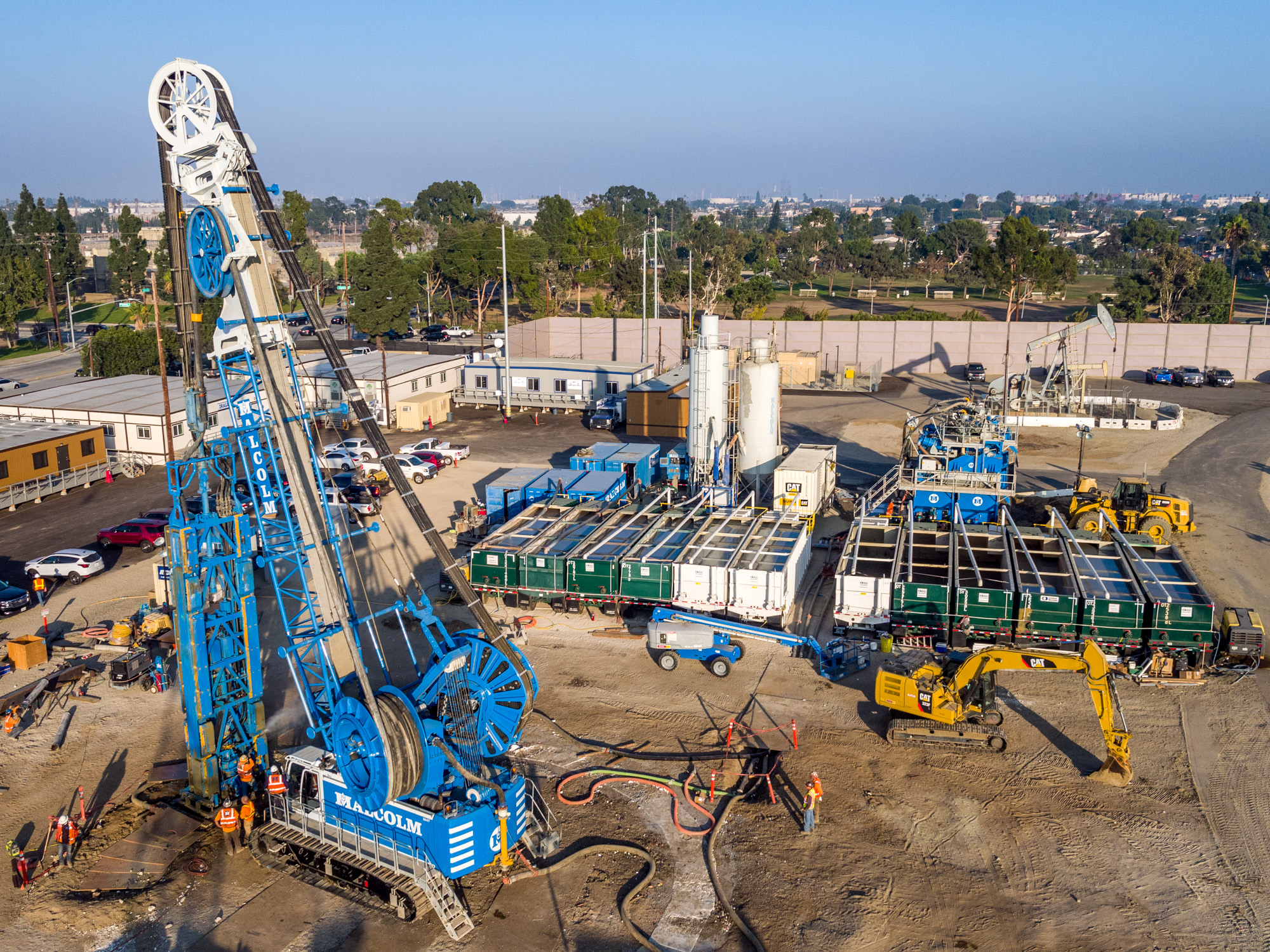 Hydromill shaft-drilling site with treatment equipment and fluid tanks