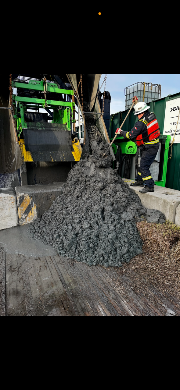 Stage 3 Separation technician handling solids beside operating equipment